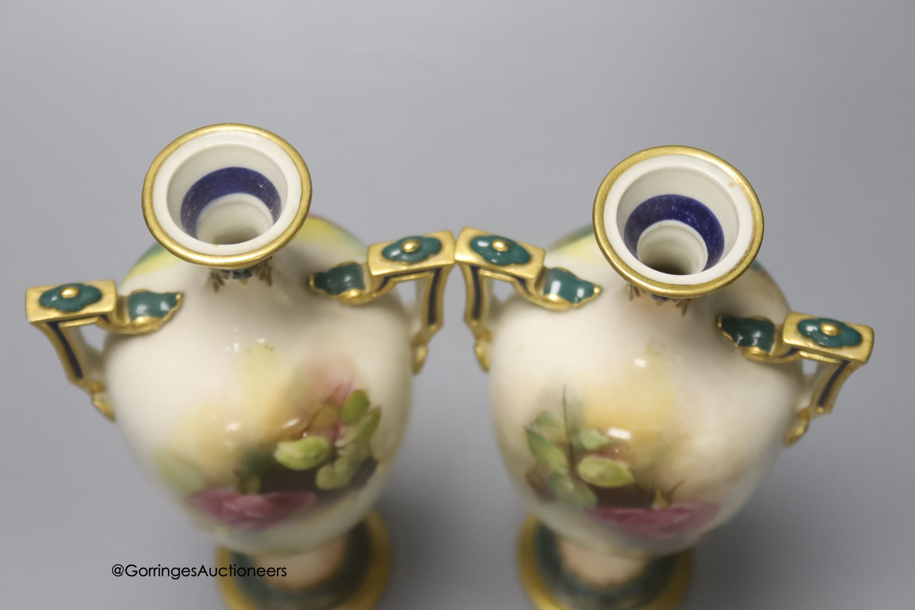 A pair of Royal Worcester two handled vases, decorated with roses, unsigned, 18cm (one a.f.)